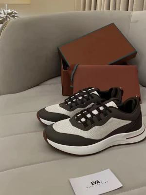Loro Piana BUD/BYTEN - Snygga sneakers i svart och vitt med modern design. Ovandelen är i mesh och syntetmaterial, med svarta detaljer och vit sula. Skorna har lågt skaft och sportig look, perfekta för en trendig streetstyle.