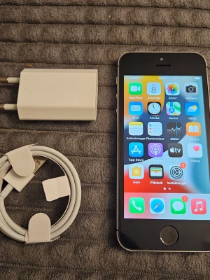 iPhone SE 32gb - Säljer en silverfärgad iPhone SE (första generationen) från Apple. Telefonen har en klassisk rektangulär form med aluminium- och glasmaterial. Medföljer vit laddare och USB-kabel. Perfekt för dig som gillar smidiga och stilrena mobiler nytt batteri batterihälsan 100%. Mobilen är olåst utloggad fungerar med alla operatörer
