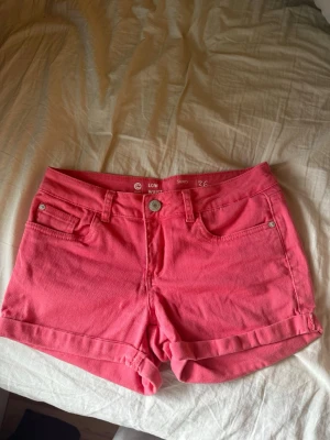 Rosa low waist shorts från C Denim - Säljer mina jättesnygga coral/rosa färgade jeansshorts. Lågmidjade och lite stretchiga. Inga defekter osv. Dragkedjan funkar bra!