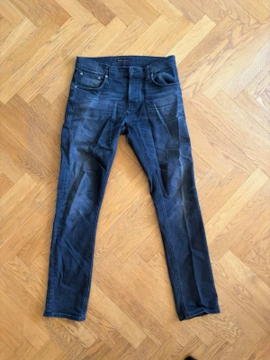 Gråsvarta nudie jeans, grim tim - Gråsvarta jeans från nudie. Modell: Grim tim. Strlk: W32 L32. Bra skicka