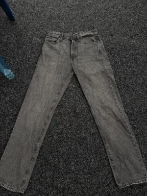Grå relaxed jeans från Jack & Jones - Snygga grå jeans från Jack & Jones i modellen RELAXED/CHRIS. Jeansen har rak passform, klassisk femficksdesign och är tillverkade i denim. Perfekta för en avslappnad och trendig stil.
