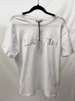 Lanvin T Shirt Vit - Väldigt stilren och unik Tshirt från det exklusiva märket Lanvin! Helt ny med tags. Storlek S, sitter normalt. Kontakta mig för fler frågor och funderingar!