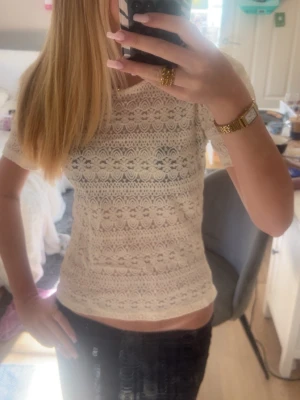 Vit spetsblus med kort ärm - Säljer en söt vit blus i spets med korta ärmar och rund hals. Blusen har ett detaljerat spetsmönster och är lätt genomskinlig, perfekt för att skapa en romantisk look. Liten i storlek och passar mig som brukar ha xs/s! Aldrig använd men har tyvärr inte prislapp kvar💓