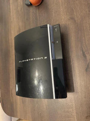PlayStation 3 spelkonsol svart - Säljer en svart PlayStation 3 från Sony. Konsolen har en blank finish och klassisk rundad design med tydlig PlayStation 3-logga på ovansidan. Perfekt för gaming och filmkvällar med vänner.