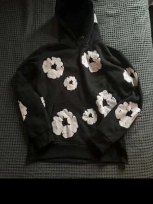 Svart hoodie med vita blommor - Hej, jag säljer nu min gamla denim tears hoodie pågrund av att jag har ish tröttnat på den. Jag har använd den 6 ggr och är i bra skick. Jag skulle nog säga att skicket är 7/10! Skriv till mig om du ör intresserad och priset går att diskutera såklart😉💸