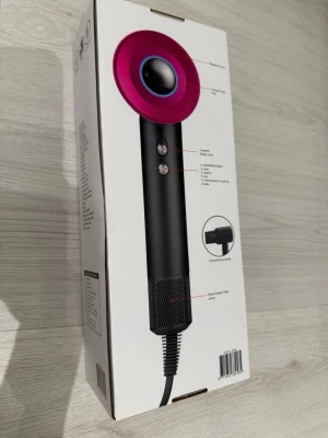 Hårtork med negativ jonfunktion 1600W - Snygg hårtork i svart och rosa med modern design. Har negativ jonfunktion, två hastigheter och fyra temperaturinställningar. Utrustad med avtagbart filter och sladd. Passar till 220-240V och har 1600W effekt. Perfekt för dig som vill ha snabb och smidig hårtorkning.