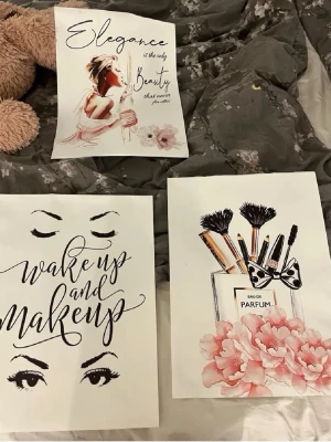 3 trendiga posters med sminktema - Säljer tre posters med smink- och skönhetstema. En med texten 'Elegance is the only beauty', en med 'wake up and makeup' och en med sminkborstar i parfymflaska och rosa blommor. Färgerna går i svart, vitt, rosa och beige. Perfekt för att piffa upp rummet.