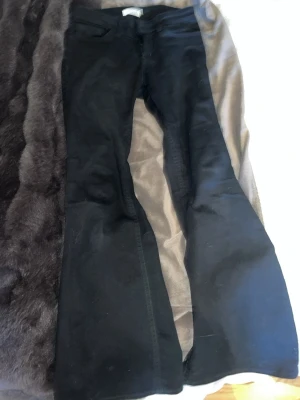 Svarta utsvängda jeans från Lindex - Snygga svarta jeans från Lindex i modellen Freja. Jeansen har utsvängda ben och klassisk femficksdesign. Perfekta för dig som gillar en trendig och bekväm stil. Materialet är mjukt och stretchigt för extra komfort.