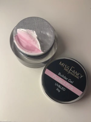 Miss Fancy Builder Gel Perfect Pink - Bygggel för naglar i färgen Perfect Pink från Miss Fancy Professional. Gelen är anpassad för UV och LED-lampor och kommer i en rund burk på 30g. Perfekt för att skapa starka och snygga nagelförlängningar med en naturligt rosa ton.