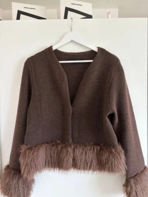 Brun kofta  med fuskpäls Zara - Snygg brun cardigan från Zara med fuskpälsdetaljer vid ärmslut och nederkant. 