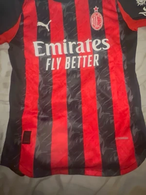Äkta AC Milan matchtröja Puma röd/svart - Äkta ac Milan match t shirt direkt från Italien helt oandvänd kom privat så kan du få fler bilder på loggan och mera som tyder på att den är äkta 