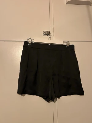 Höga festliga shorts - Dessa shorts funkar perfekt på fest, då de är riktigt stiliga. Ett glansigt rakt material gör att de sitter snyggt. Är helt oanvända med lapp kvar.  Nypris 249 kr.