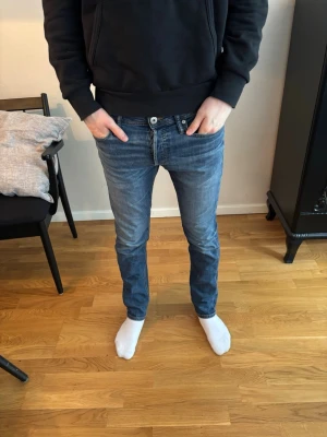 Blå slim fit jeans från Jack&Jones - Säljer ett par blå slim fit jeans från Jack&Jones. Som man ser i bilden så är det en liten fläck men den syns knappt! Jag säljer dom för 199kr! Skriv om du har några funderingar.