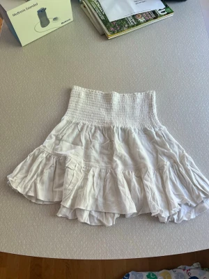  Snygg vit volangkjol från lager 157 - Söt vit kortkjol med volangkant. Kjolen har en luftig känsla och är perfekt för varma dagar. Tillverkad i ett lätt tyg som ger en avslappnad och trendig look. Använd några enstaka gånger💓💓 perfekt nu till sommaren💓