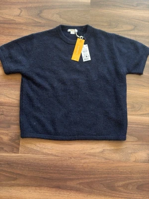 Mörkblå stickad t-shirt Gina Tricot - Oanvänd mörkblå stickad t-shirt från Gina Tricot Young i storlek 158/164.