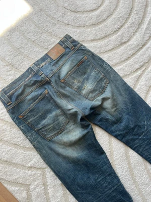 Nudie Jeans Grim Tim - Ett par Nudie Jeans med slitningar, Grim Tim!☀️Hör av dig vid funderingar!