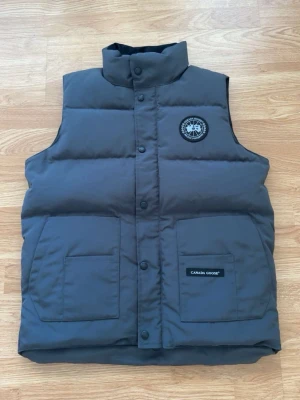 Canada Goose väst  - Grå Canada Goose Väst – Black Label 🦾⚫️            - Skick: 10/10 – Helt ny, aldrig använd och alla tags sitter kvar!                                                                        - Storlek: M                                                                      - Modell: Freestyle                                                      🚀 Snabb frakt och spårbart paket!                                           📩 DM vid köp, frågor eller om du vill ha fler bilder.