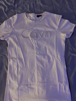 Vit Calvin Klein t-shirt - Snygg vit t-shirt från Calvin Klein med broderad logga framtill. Klassisk rund halsringning och korta ärmar. Perfekt basplagg med stilren design och mjukt material.