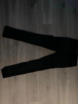 Svarta skinny jeans - Säljer ett par svarta skinny jeans med hög midja och smal passform. Klassisk femficksmodell och dragkedja med knapp framtill. Perfekta till en avslappnad streetstyle-look.