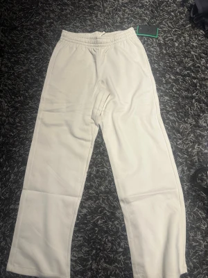 mjukisbyxor - Säljer ett par mjukisbyxor med rak passform och resår i midjan. Byxorna är enkla och stilrena, perfekta för en avslappnad look. Materialet känns mjukt och bekvämt mot huden.