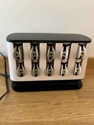 Värmespolar - Säljer ett set med värmespolar i en smidig vit och svart förvaringsbox. Perfekt för att skapa volym och lockar i håret. Spolarna är klädda med sammet och har tillhörande klämmor. Observera att sladden är amerikansk, en adapter behövs alltså. 