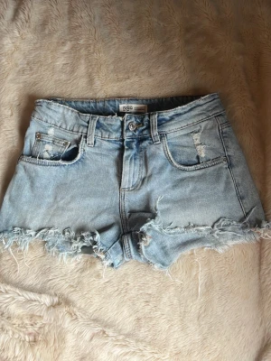 Ljusblå denimshorts med fransar - As snygga jeans shorts från Zara, gammal modell finns ej att köpa.