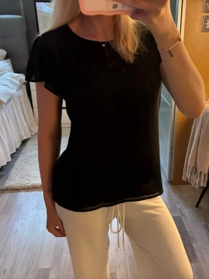 Svart blus med korta ärmar - Snygg svart blus med rund halsringning och korta, lösa ärmar. Blusen år feån H&M i storlek 38💕