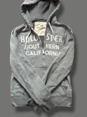 Grå hollister hoodie - Grå hollister hoodie säljer eftersom den inte kommer till någon användning längre och är i mycket bra skicka vill helst bli av med så snabbt som möjligt❤️‍🩹