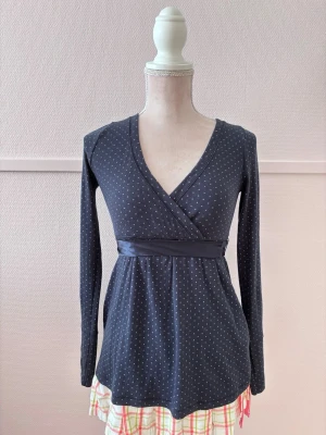 Hollister babydoll top - Säljer denna söta marinblåa babydoll toppen med prickar på och ett sidenband i midjan! Den är i storlek S men kan också passa storlek XS. Den har tecken på användning så som nopprig.  Skickar inga fler bilder. Använd köp nu knappen! 💗