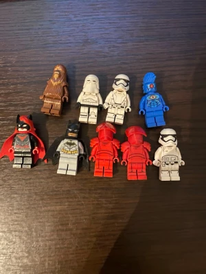 Lego minifigurer Star Wars & DC - Säljer ett gäng Lego minifigurer från Star Wars och DC-universumet. Bland figurerna finns Chewbacca, stormtroopers, två röda vakter, Batman, Batwoman och en blå figur med öga på bröstet. Perfekt för samlare eller lek. Alla figurer är i plast och har detaljerade tryck.   Prutning kan ske