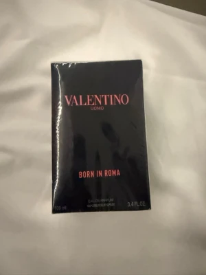 Valentino Uomo Born In Roma parfym - Valentino Uomo Born In Roma är en lyxig parfym i en elegant svart förpackning med rosa text. Flaskan rymmer 100 ml och är designad för att sticka ut med sin stilrena och moderna look. Perfekt för dig som vill ha en exklusiv doftupplevelse.