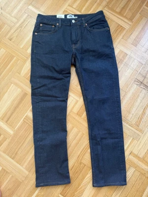 Mörkblå raka jeans från Great Racing - Snygga mörkblå jeans från Great Racing i rak modell. Klassisk femficksdesign med kontrastsömmar och kopparfärgade nitar. Jeansen har normal midja och är tillverkade i ett slitstarkt denimtyg. Perfekta för en stilren och enkel look. Helt nya och oanvända 
