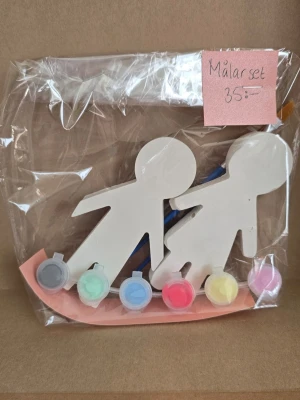 Målarset med figurer och färger - Ett målarset med två vita figurer i gips med gärg och penslarl. Allt är förpackat i en plastpåse och redo att användas för kreativt pyssel.