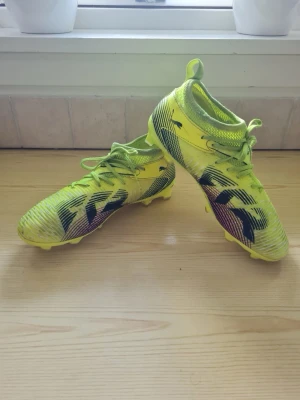 Puma Future 8 Match fotbollsskor strl 35 barn junior - Fotbollsskor med FG-/AG-dobbar för spel på både konstgräs och naturgräs. Innovativa 3D-printade detaljer på nyckelområden säkerställer optimal bollkontroll.  FUTURE 8 Match FG/AG från Puma är utrustade med en FUZIONFIT-överdel. Denna överdel är tillverkad i ett ventilerande meshmaterial och bidrar till god ventilation och komfort.  Skorna är också utrustade med en Lightweight Dynamic Motion System-yttersula, vilken säkerställer optimal stabilitet och är utformad för snabba riktningsändringar. Su