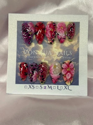 SafariLuxe (M);Medium Almond - Unika handgjorda press-on naglar i en medium lång mandelform med handmålat mönster i rosa, rött och svart. Naglarna har detaljer som blommor, leopardfläckar och fransk manikyr. Materialet är akryl och designen är riktigt färgstark och kreativ. Perfekt för dig som vill sticka ut med dina naglar.