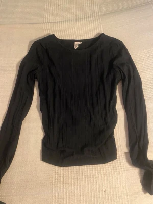 Svart tröja med öppen rygg  - Svart långärmad tröja från Nelly som är perfekt till fest eller bara i vardagen