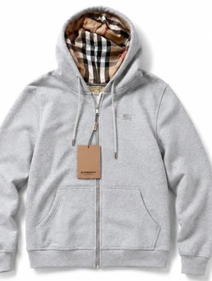 Grå zip hoodie från Burberry - Snygg grå zip hoodie från Burberry med klassiskt rutigt foder i huvan och diskret logga på bröstet. Hoodien har dragsko i huvan, fickor framtill och är tillverkad i mjukt bomullsmaterial. Perfekt för en chill och stilren look.