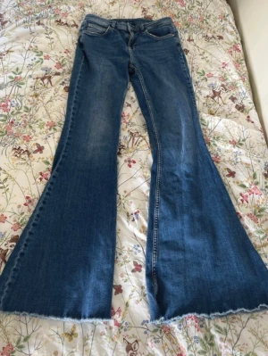 Liu Jo utsvängda jeans med rhinestonedetaljer - Benöppning: 33 cm ✨Innerben: 82 cm (för långa på mig som är 162) ✨Midjehöjd/ Rise = 23 cm ✨Midja: 35 cm ✨Höfter: 40 cm ✨PASSAR MIG SOM HAR STORLEK M. ❗️Lätt slitage vid fickkanterna, annars finns inga defekter utöver faktumet att de behöver strykas. 