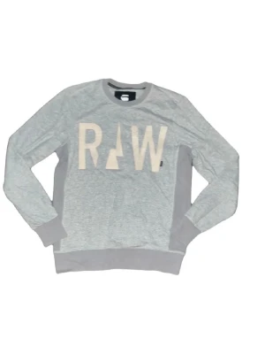 G-Star RAW tröja  - Grå sweatshirt från G-Star RAW med stora vita bokstäver 'RAW' framtill. Tröjan har rund hals, ribbade muddar och nederkant samt långärmad passform. Tillverkad i mjuk bomullsmix som är skön att bära. Perfekt för en chill och stilren look. KOLLA måtten för storlek. Tröjan kan möjligen krympt i tvätten.