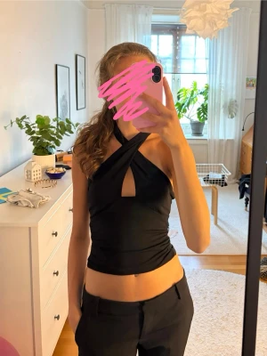Svart omlott halterneck topp  - Säljer en jättefin svart halterneck topp med omlott-design från BikBok. Storlek XS. Använd 1 gång, så mycket bra skick! Kontakta vid frågor💕