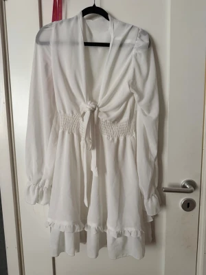 Vit ruffle dress sommarklänning - Använd 2-3 gånger förra året den har den mest hängt här hemma. Klänningen är från Dressy men jag hittade ingen lapp på klänningen som jag kunde ta bild på tyvärr, ni får bara lita på mig. Ignorera att jag la in bilderna från min skolavslutning jag hade inga bättre bilder på den😅den ÄR i storlek L men jag skulle säga att den passar mycket bättre om din storlek är M. Den är lite genomskinlig också som ni ser på bilderna.