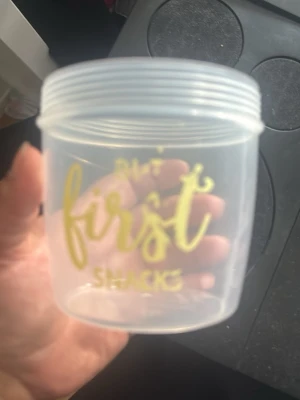 Transparent plastburk med gul text - Säljer en liten transparent plastburk med gul text där det står 'But first snacks'. Perfekt för att förvara snacks eller småsaker. Burken har skruvlock och är lätt att ta med sig i väskan.