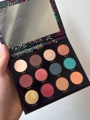 Salvaje ögonskuggspalett ColourPop - Färgstark ögonskuggspalett från ColourPop i samarbete med Becky G. Innehåller 12 nyanser i matta, skimriga och glittriga toner som guld, turkos, koppar, vinröd, persika och beige. Paletten har spegel och snyggt blommigt fodral. Bara provad.