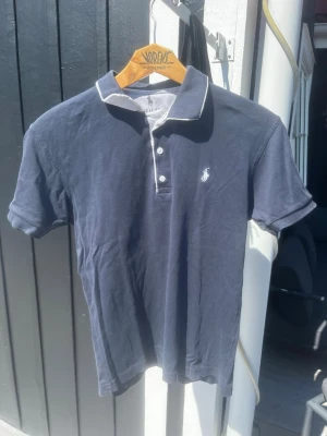Mörkblå pikétröja från Polo Ralph Lauren - Tja, säljer min piké ifrån polo Ralph lauren! I väldigt fint skick. Bara att skriva vid andra funderingar. Först till kvarn!🤩                             mvh Consentuedo!