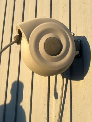 Grey hose winder for wall mounting 20 meter - Sells a round hose winder in gray plastic that is mounted on the wall. Perfect for keeping the garden hose neatly rolled up and easy to use. Modern design with the hose integrated into the housing. Easy to pull out and roll in the hose again. (Pick up from Svalöv)