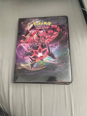 En full Pokémon pärm och 50-70 andra lösa kort  - Säljer en Pokémon Trading Card Game-pärm med färgglatt tryck och flera samlarkort inuti, bland annat olika Pikachu-kort och andra populära Pokémon. Perfekt för dig som vill utöka din samling eller börja samla Pokémonkort.