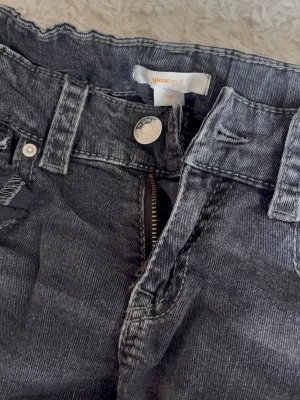 Svarta jeans från Gina Tricot - Snygga svarta jeans från Gina Tricot i klassisk femficksmodell. Jeansen har dragkedjegylf, bälteshällor och en cool tvättad look. Perfekta för dig som gillar en avslappnad och trendig stil. Bootcut jeans!
