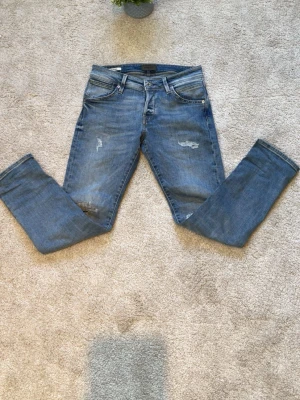 Jack&jones jeans - Säljer mina feta jack&jones jeans i storlek L30 W30 i en ljus blå färg. Riktigt feta jeans med slitningar. I en slim fit Dessa jeans säljs inte längre på deras hemsida eller i butik