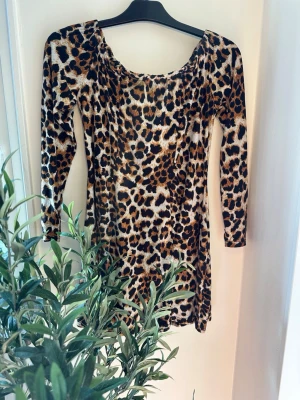 Leopardmönstrad kort klänning storlek: M - Snygg kort klänning med leopardmönster och lång ärm. Klänningen har en rundad halsringning och figurnära passform, perfekt för dig som vill sticka ut. Materialet känns mjukt och följsamt mot kroppen.
