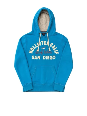 Blå hoodie från Hollister - Snygg blå hoodie från Hollister med vit text och broderad logga på bröstet. Skick 9/10 hör av dig vid fundering